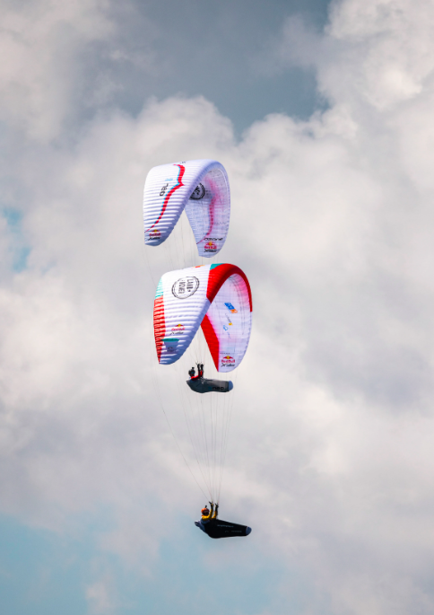 Parapendio in volo tra le nuvole alla X-Alps